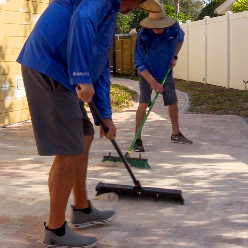 An image of two men cleaning pavers.