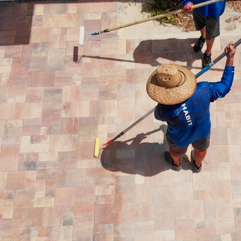 An image of two men sealing pavers.